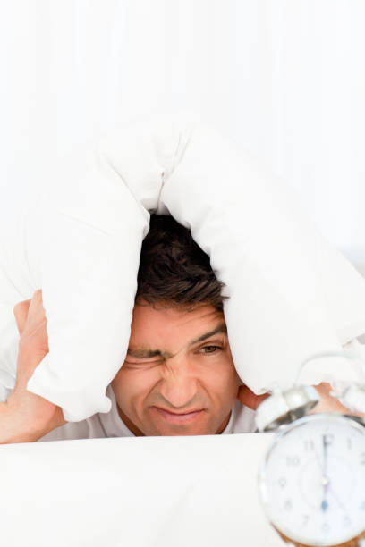 istock Handsome man lying on his bed and looking at his clock 850760596