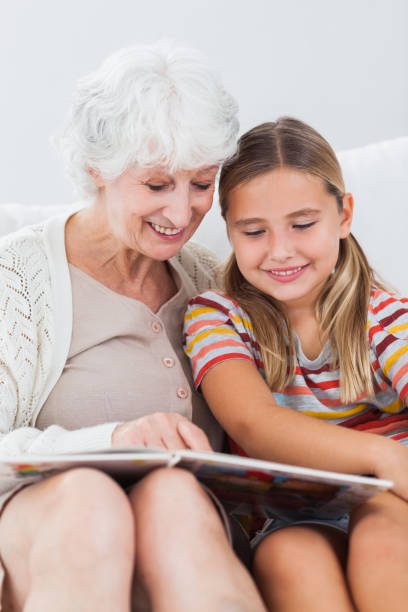 istock Little girl reading with granny 850763580