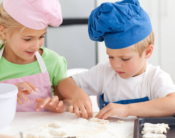 istock Young brother and sister kneading a dough to make cakes 850790906