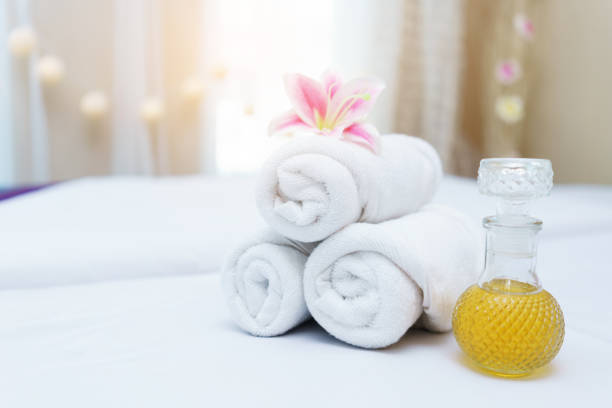 istock White towel rolls on top with pink Lily flower and Essential oils prepared on massage table for spa treatment 850800866