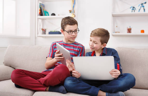 istock Two teenage boys using tablet on couch at home 850800900