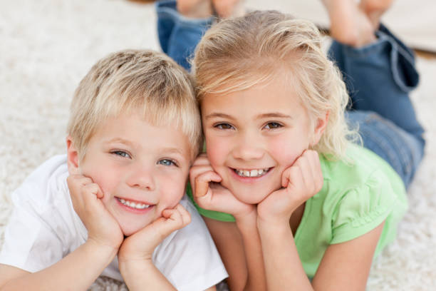 istock Brother and sister looking at the camera on the floor 850801176