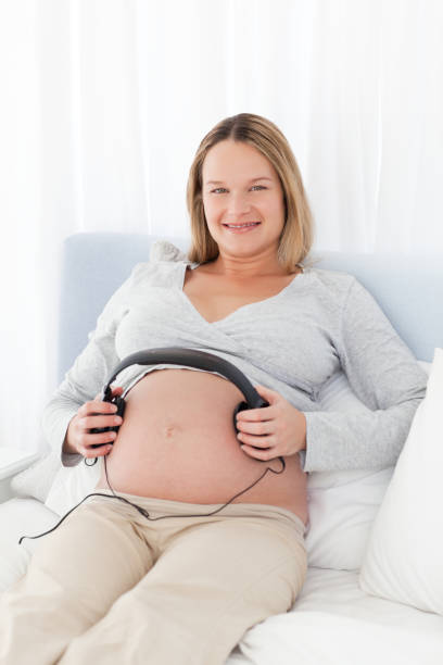 istock Future mom putting headphones on her belly 850801316