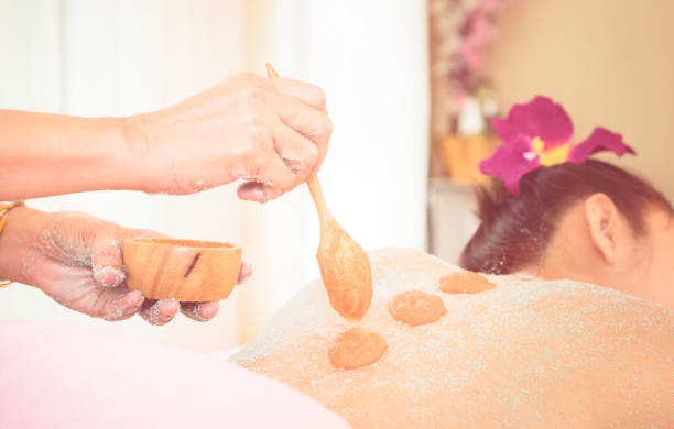 istock Spa Therapist is putting Orange salt scrub on to a women back 850808428