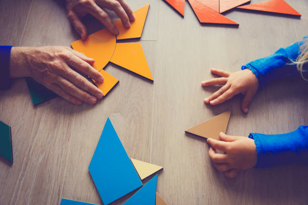 istock teacher and child playing with geometric shapes 850808610
