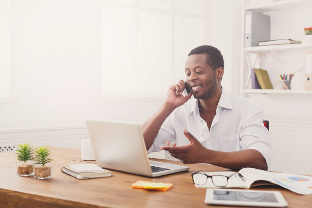 istock Young black businessman talking on mobile in modern white office 850811904