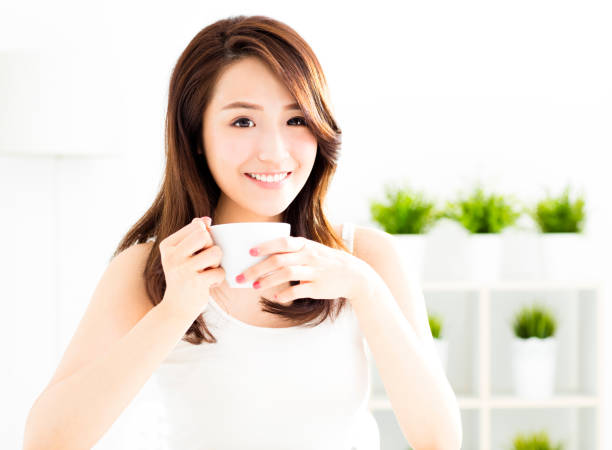 istock beautiful young asian woman drinking coffee 850832718