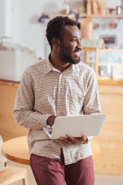 istock Charming man leaning on table and holding laptop 850833330
