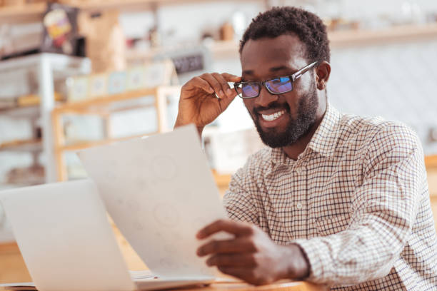 istock Cheerful man looking through research results in cafe 850837148