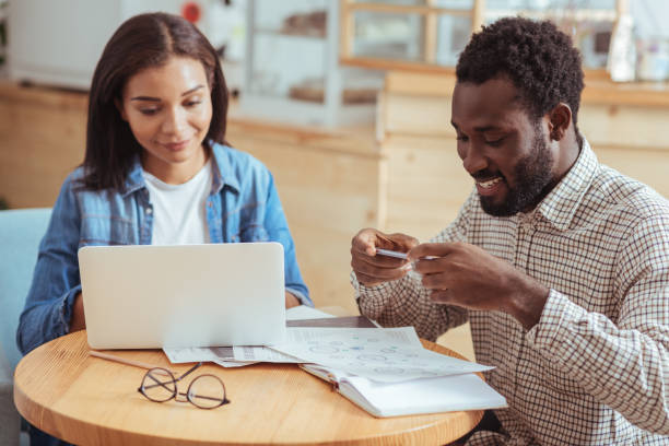 istock Pleasant man taking photo of printout while working with colleague 850837792