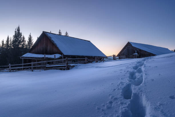istock Two wooden cabins in the winter forest at the sunset 850838228