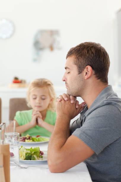 istock Adorable father and daughter praying during the lunch 850841376