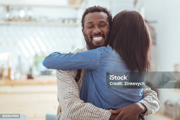 Happy Man Hugging His Best Friend In Coffeehouse Stock Photo - Download Image Now - Reunion - Social Gathering, Couple - Relationship, Backpack