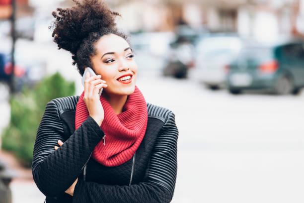 istock Smiling african woman using smart phone on street 850845368