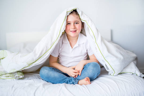 istock Adorable little boy in white t-shit lying in bed 850845756