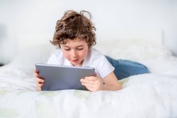 istock Adorable little boy in white t-shit lying in bed 850846046