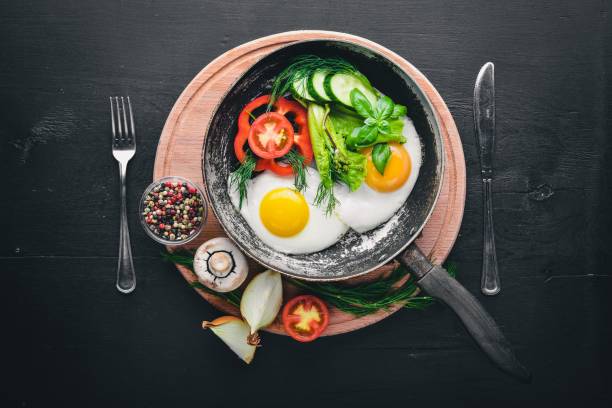 istock Fried egg with herbs and vegetables in a frying pan. Top view. Free space. 850852618