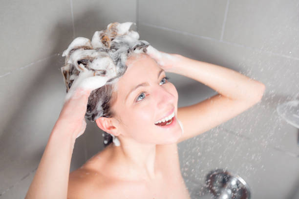 mujer en la ducha, lavar el cabello con champú - bathtub women naked human face fotografías e imágenes de stock