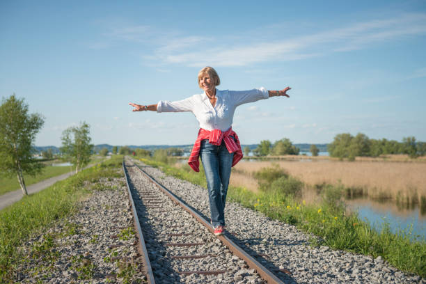 istock smiling senior lady having fun balancing on rails 850858802