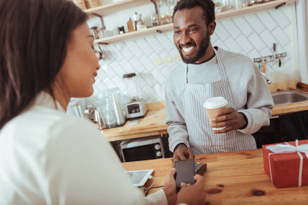 istock Pleasant woman using NFC technology to pay in cafe 850858812