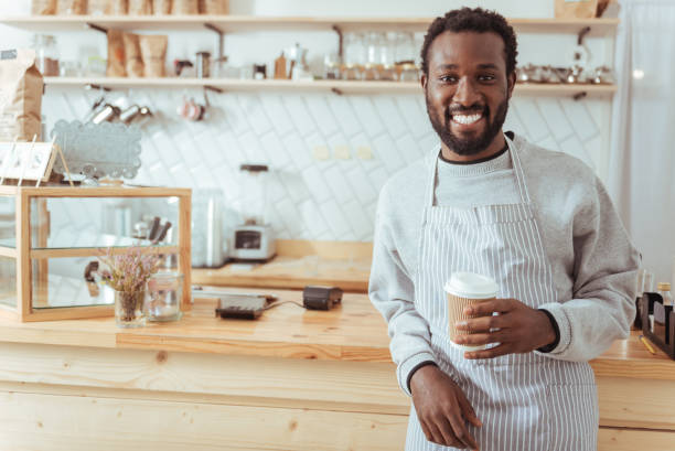 istock Smiling barista posing with a cup of coffee 850858876
