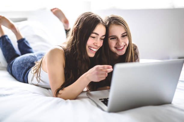 istock Teen Girls Lying On Bed Using A Laptop 850868724