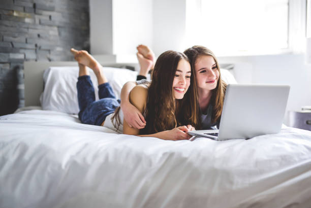 istock Teen Girls Lying On Bed Using A Laptop 850868876