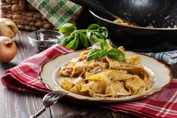 istock Pappardelle pasta with prosciutto and cheese sauce on a plate 850872738