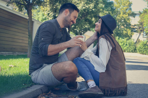 istock Happy young couple sitting in the park drinking coffee 850875760