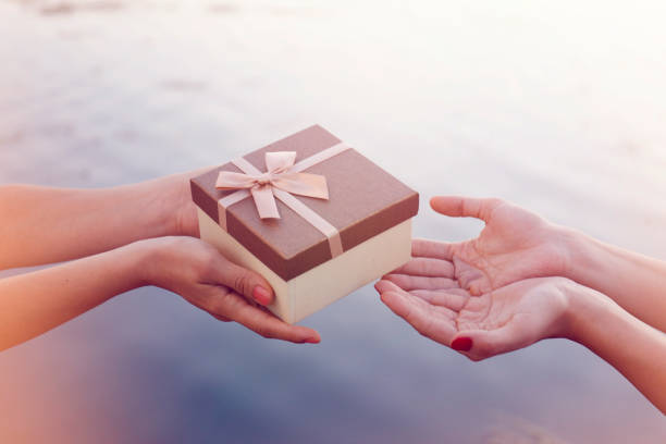 Closeup hands giving and receiving gift box