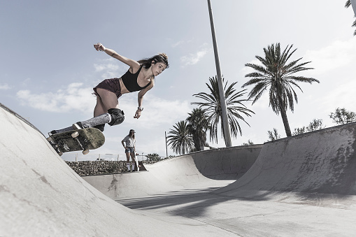 Young woman skateboarding in skatepark