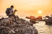 Woman with a dog hiking along the seashore