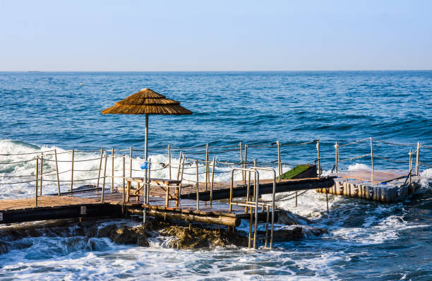 嵐と海の背景の桟橋 sunumbrella - cyprus paphos storm sea ストックフォトと画像