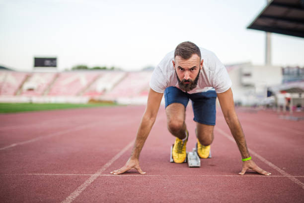 Preparing for the championship 35 years old man is practicing running at the field. He is preparing for the championship start block stock pictures, royalty-free photos & images