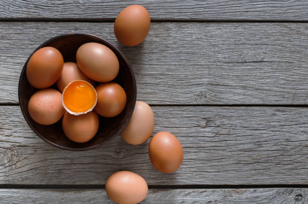 istock Brown and white organic eggs in bowl on wood background 850916264