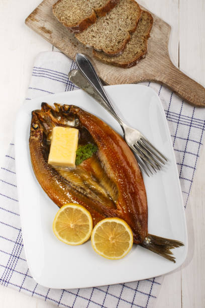 scottish smoked kipper with lemon, butter and parsley on a plate
