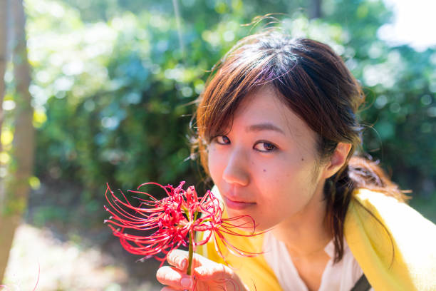 Happy woman smelling red spider lily