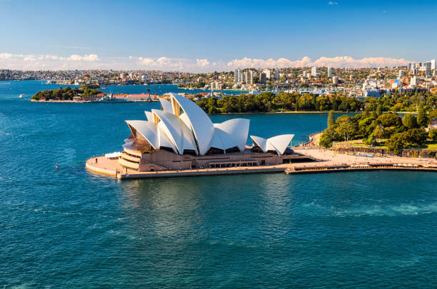Sydney Opera House In The Sun Sydney Australia - August 4, 2017: A clear morning in Sydney, New South Wales, and this is the view looking across Circular Quay towards the iconic shape of the city's Opera House. In the distance we see the Royal Botanic Gardens. sydney stock pictures, royalty-free photos & images