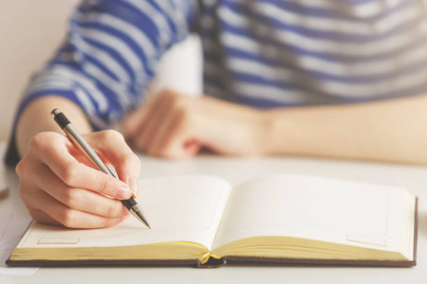 istock Woman writing in hardcover notepad 850942966