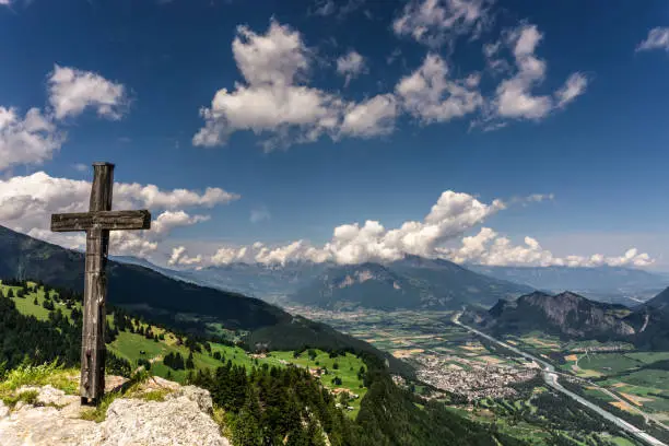 the Rhine Valley near Maienfeld and Bad Ragaz in the Swiss Alps with a summit cross in the foreground