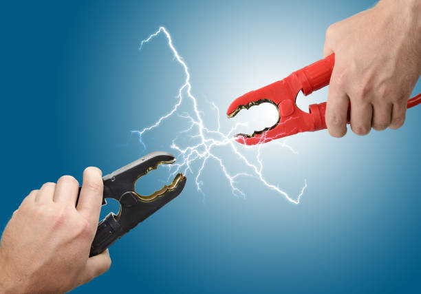 Hands holding jump start connectors Hands holding jump start connectors with sparks between them sparks photos stock pictures, royalty-free photos & images