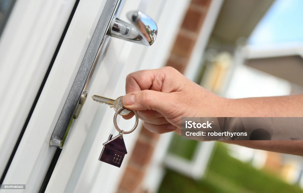 Opening a door to house with key Key Stock Photo