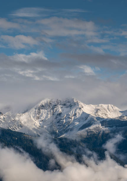 Snow covered mountains in the Swiss Alps near Chur with mist and clouds in the foreground