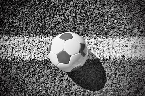 shot of a traditional soccer ball soccer on soccer field in black and white