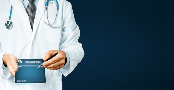 Doctor in white coat with stethoscope holds in his hand  digital tablet with history of the disease (patient consent) and pen for digital signature. Healthcare Medicine Concept