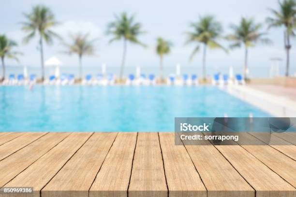 Empty Wooden Table In Front With Blurred Background Of Swimming Pool At Beachspace For Montage Products Stock Photo - Download Image Now