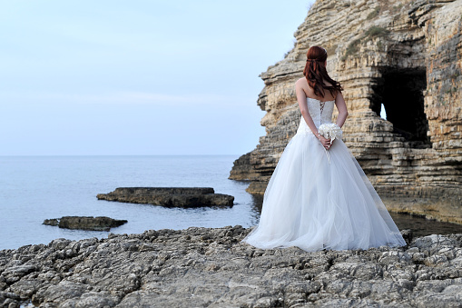 Young beautiful lady in wedding dress outside