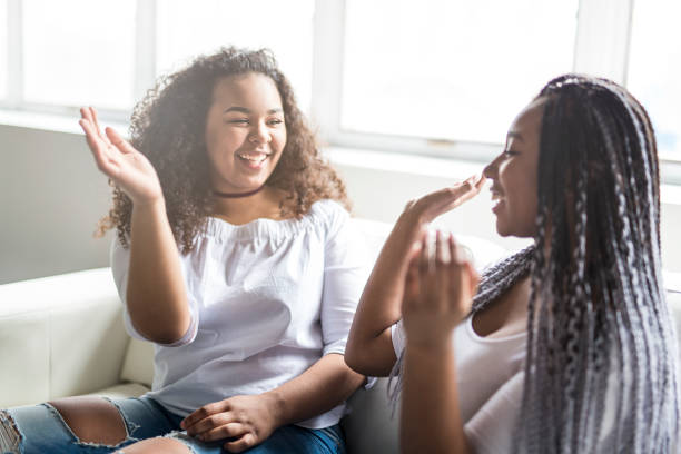affectionate friends afro american sitting on sofa