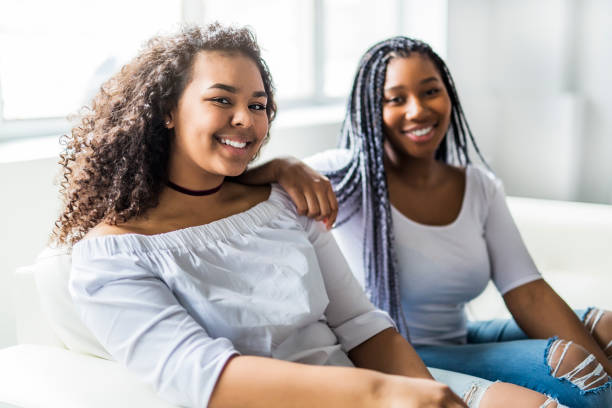 istock affectionate mother and daughter sitting on sofa 850982264