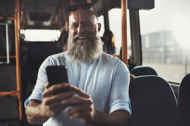 istock Laughing mature man reading texs while riding on a bus 850992846